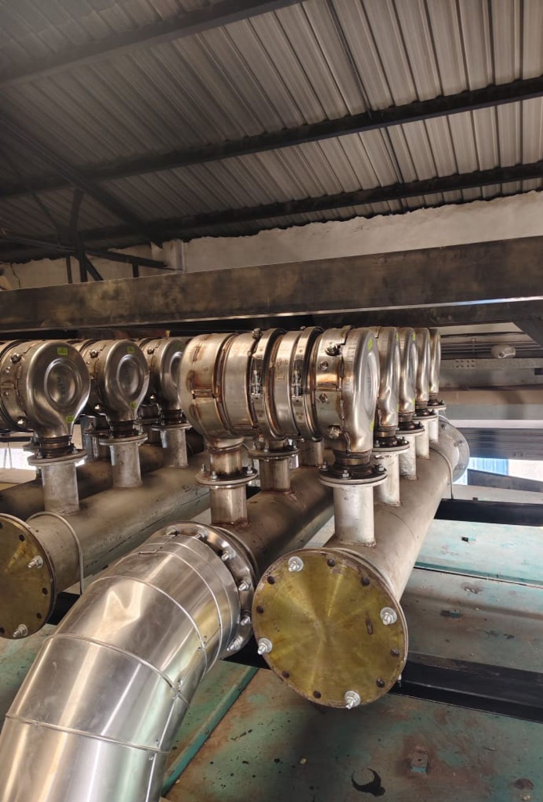 Large green industrial power generation engine with cooling fan and exhaust system.