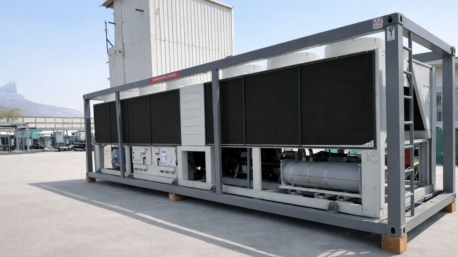 Large industrial air conditioning unit or HVAC system mounted outdoors against a cloudy sky.
