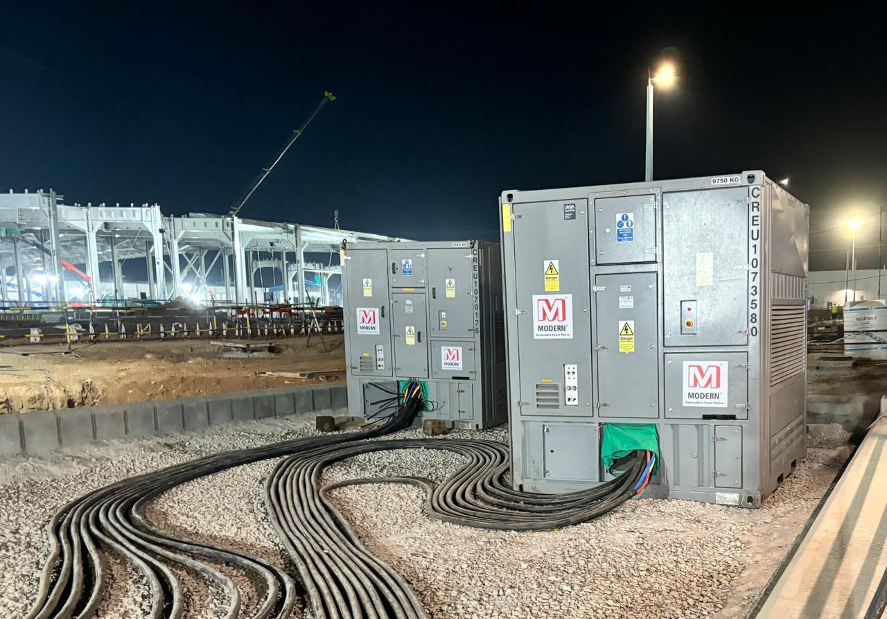 Large white industrial load bank unit with ventilation panels and Modern logo on the side.