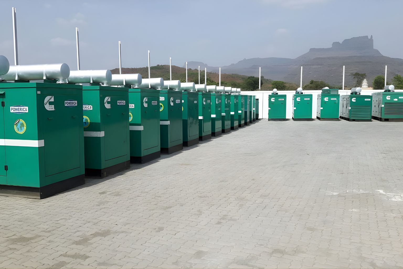 Green generator labeled Modern Hiring Service mounted on a small platform at the back of a boat named M.L. Neverland on a body of water.