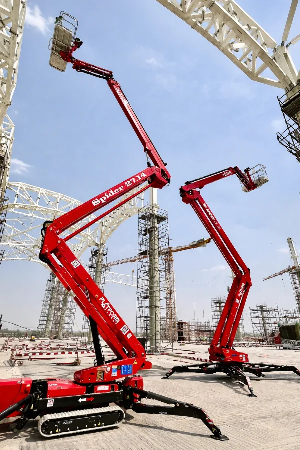 Red spider lift with extended articulated arms and a platform basket, supported by four black stabilizing legs.