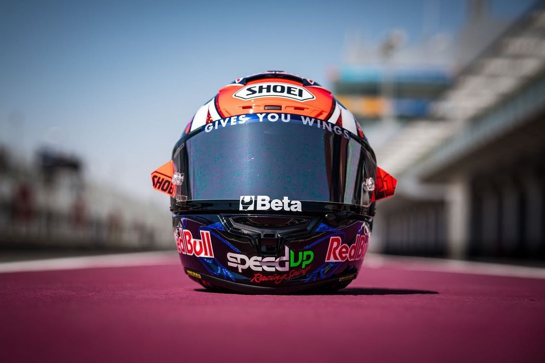 Racing helmet with Shoei, Red Bull, Beta, and Speed Up Racing logos placed on a race track.