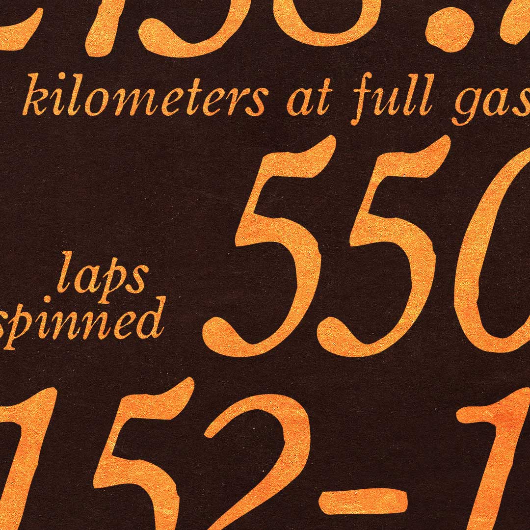 Close-up of orange text on black background showing the numbers 550 and words 'kilometers at full gas' and 'laps spinned'.