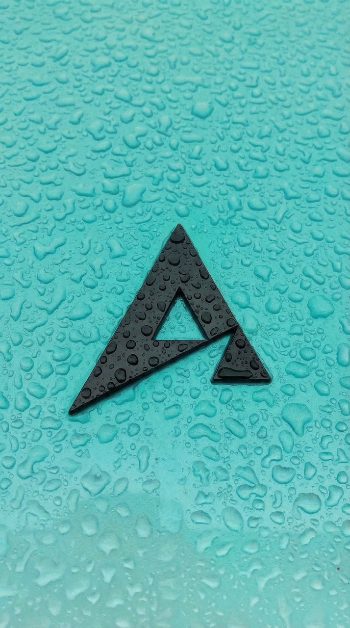 Black triangular logo with water droplets on a turquoise surface.