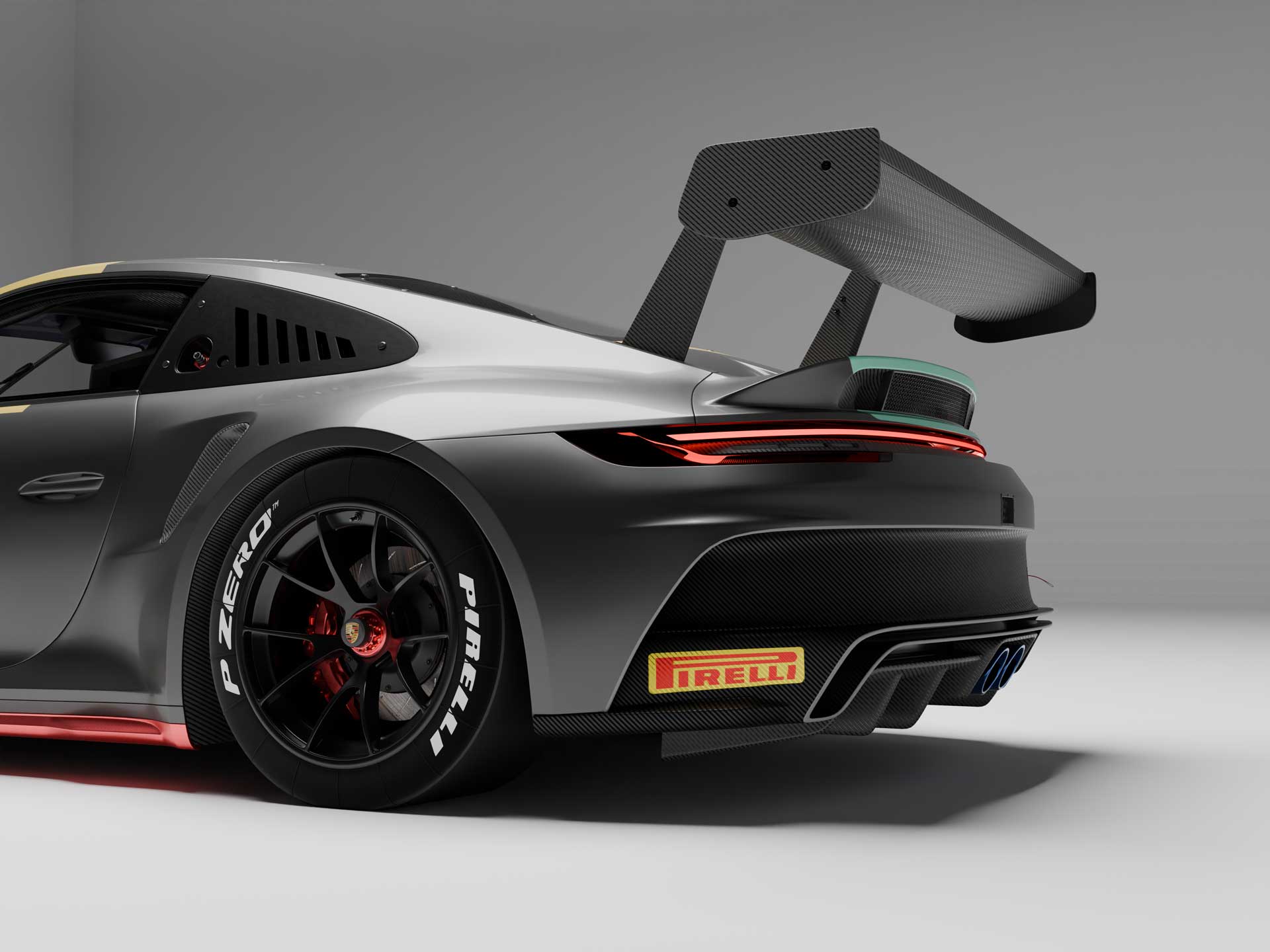 Rear and side view of a silver and black sports car with a large carbon fiber rear wing and Pirelli P Zero tires.