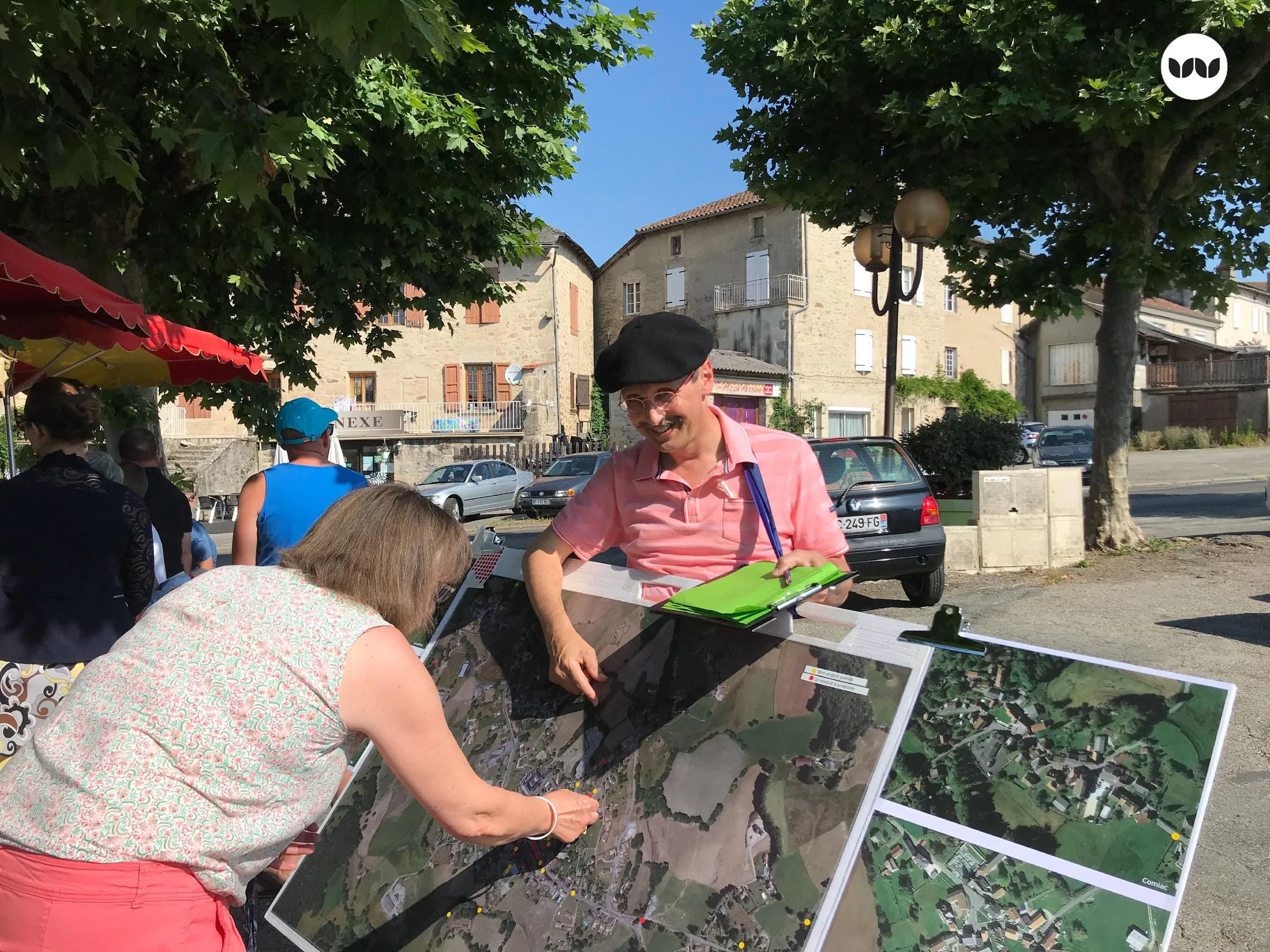 Habitant annotant une carte aérienne lors d'un marché