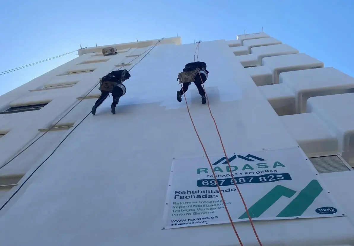 Dos hombres pintando una fachada