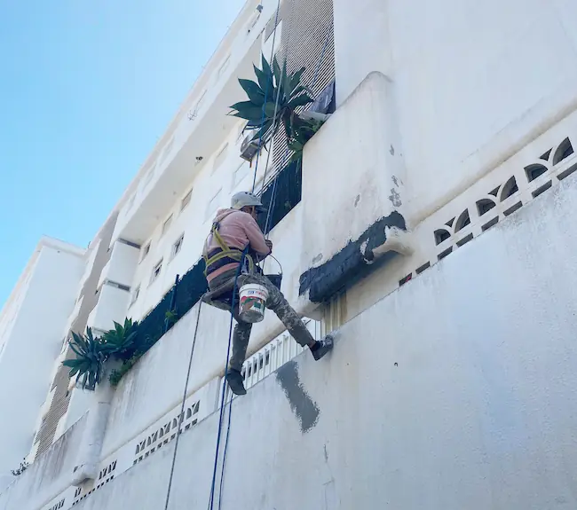 Hombre reparando fachada