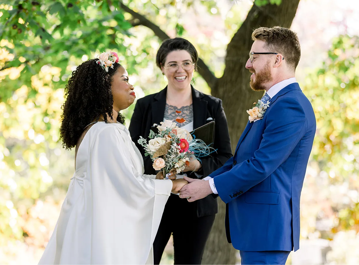 A couple standing in front of the officiant