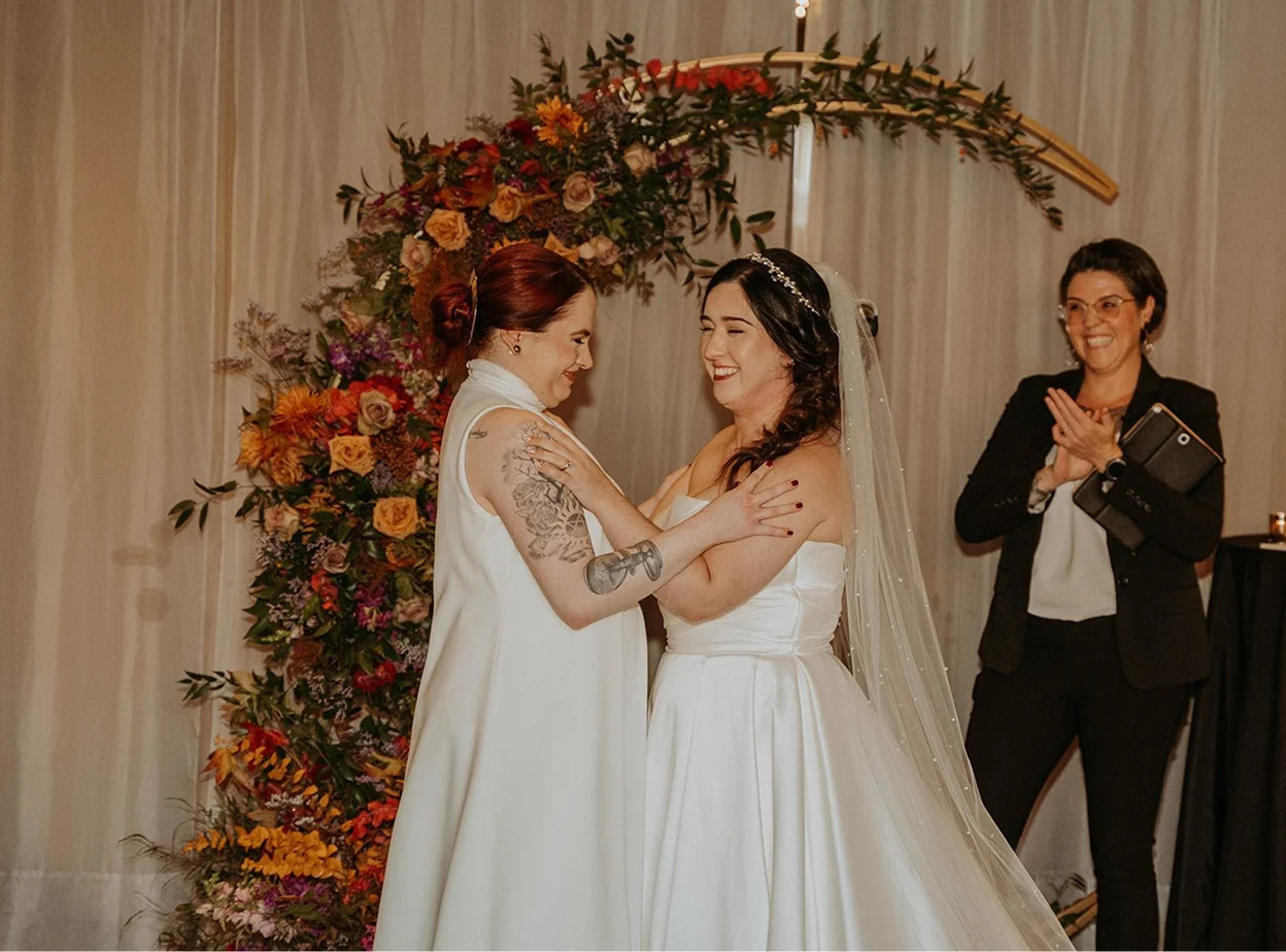 A couple standing in front of the officiant
