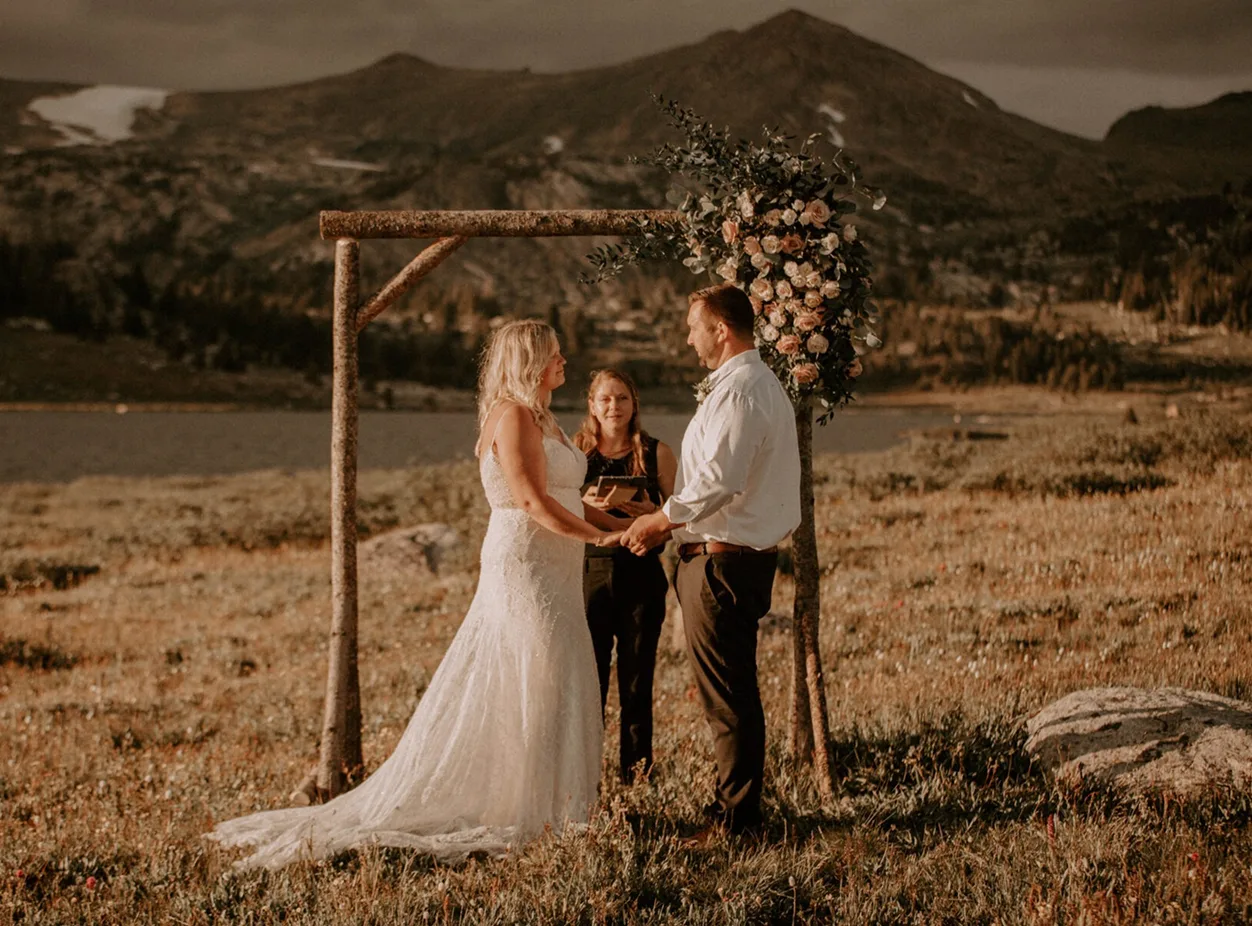 A couple standing in front of the officiant