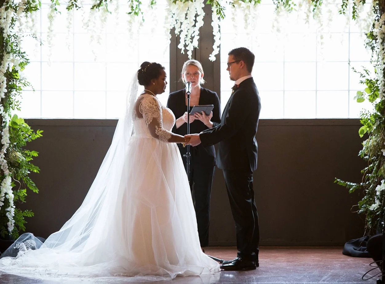 A couple standing in front of the officiant
