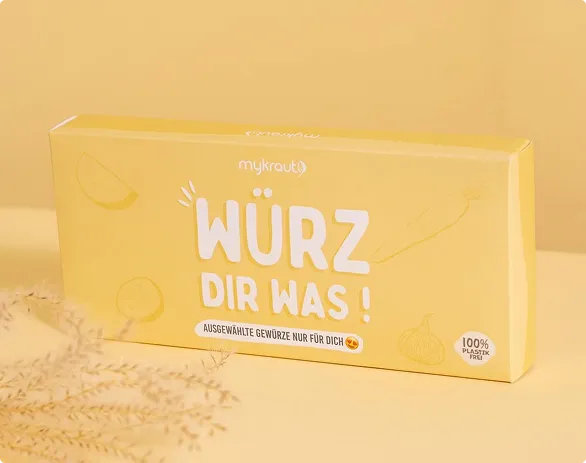 Gelbe Verpackung von mykraut mit dem Slogan 'Würz dir was!' und dem Hinweis auf 100% plastikfreie Verpackung.