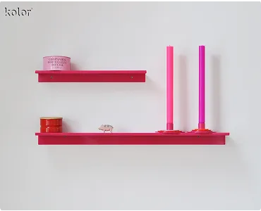 Zwei pinke Wandregale mit Dosen, kleinen Dekorationsobjekten und zwei pinken Kerzen.