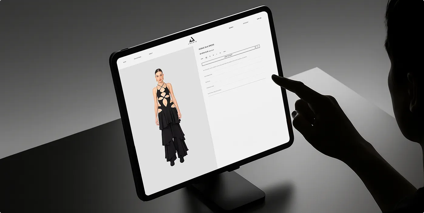 Person tippt auf ein Tablet, das eine Produktseite für ein schwarzes, mehrlagiges Kleid mit Ausschnitten zeigt.
