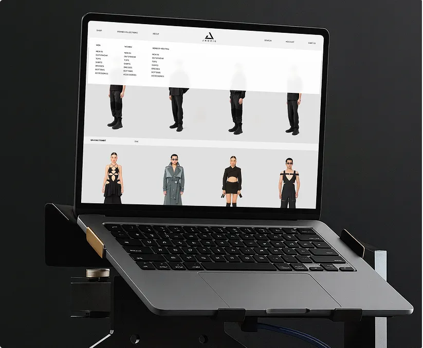 Laptop mit einer Mode-Website, die verschiedene Kleidungskategorien und Models in trendiger schwarzer Kleidung zeigt.