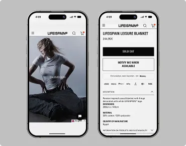 Zwei Smartphones zeigen die LIFEISPAIN Webseite: Links eine Person mit LIFEISPAIN Bluse, rechts die Produktseite der ausverkauften LIFEISPAIN Freizeitdecke mit Details und Benachrichtigungsoption.