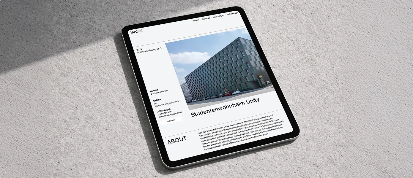 Tablet zeigt eine Webseite mit einem großen schwarzen Gebäude, das Studentenwohnheim Unity in München-Pasing darstellt.