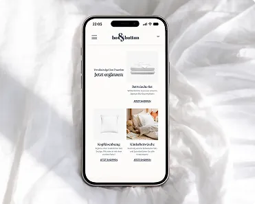 Smartphone displaying a bedding product webpage including pillowcases and duvet covers on a white bedsheet background.