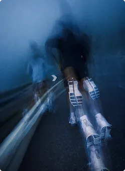 Verschwommene Aufnahme von einer Person, die nachts auf einer Straße läuft, mit Fokus auf die Sohlen der Sportschuhe.