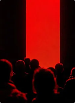 Silhouetten von Menschen, die vor einem großen roten leuchtenden rechteckigen Bildschirm oder Fenster stehen.