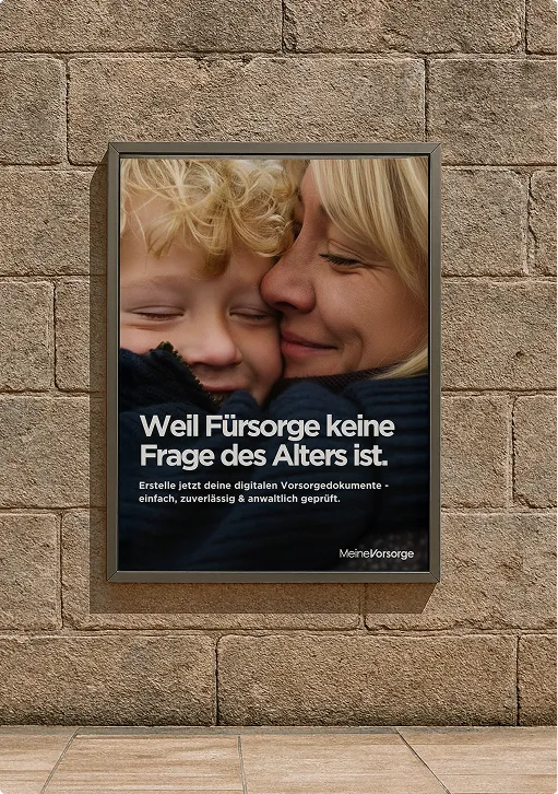 Plakat an einer Steinwand mit Bild einer lächelnden Frau und eines Kindes, Text: "Weil Fürsorge keine Frage des Alters ist."
