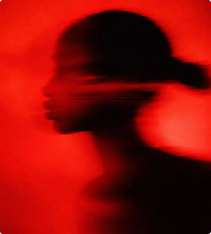 Silhouette eines verschwommenen Profils einer Person vor einem roten Hintergrund.