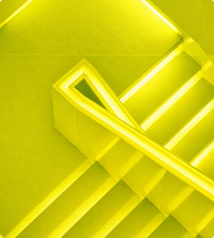 Gelb beleuchtetes Treppenhaus mit moderner, minimalistischer Gestaltung und seitlicher Brüstung.