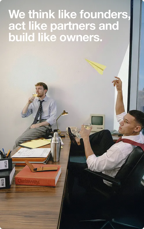 Two business men in an office, one drinking and the other throwing a paper airplane, with text that reads 'We think like founders, act like partners and build like owners.'