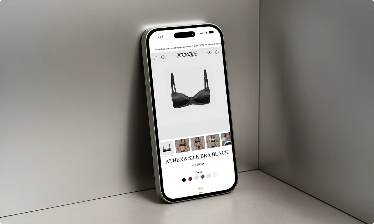 Smartphone zeigt die Produktseite eines schwarzen Athena Seiden-BHs auf einer E-Commerce-Website.