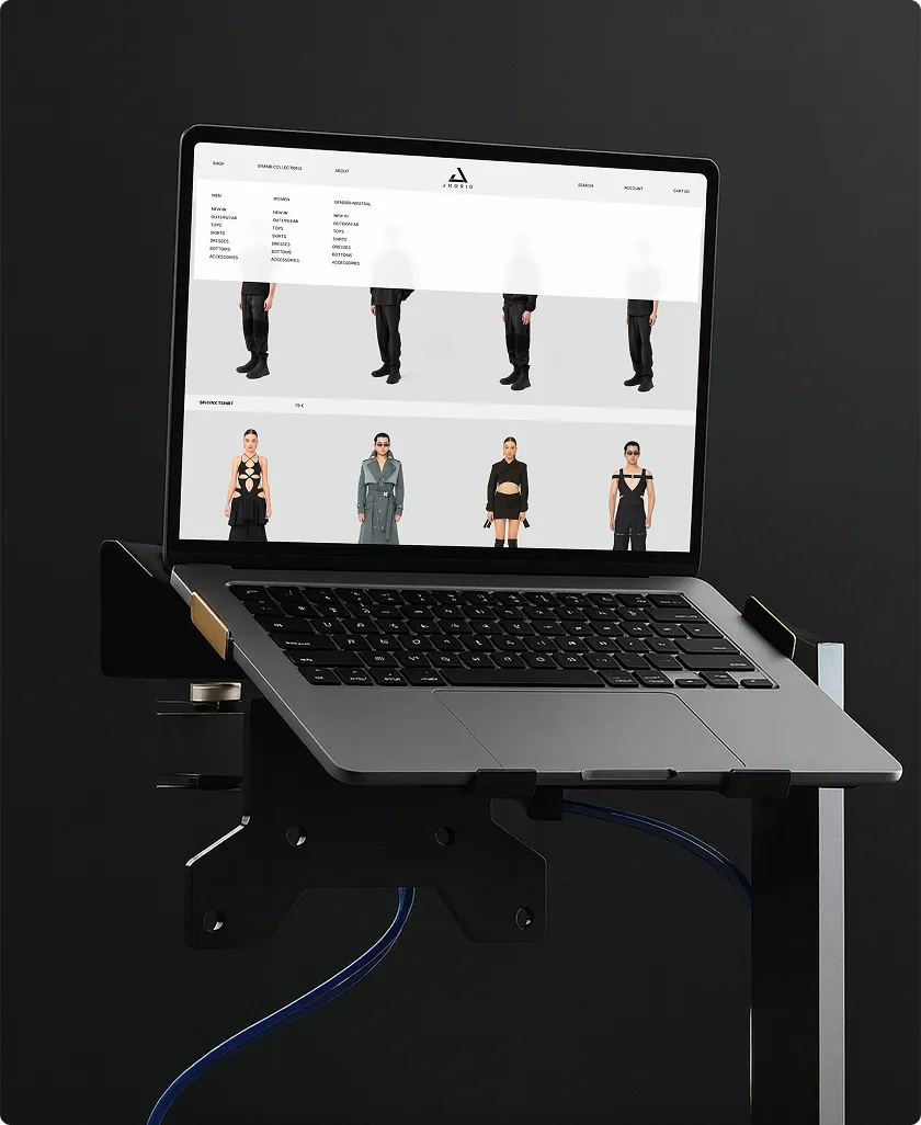 Laptop auf einem Halter mit schwarzem Hintergrund, zeigt eine Mode-Website mit Models in verschiedenen Outfits.