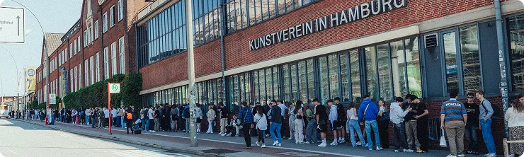 Lange Warteschlange von Menschen entlang des Gebäudes des Kunstvereins in Hamburg.