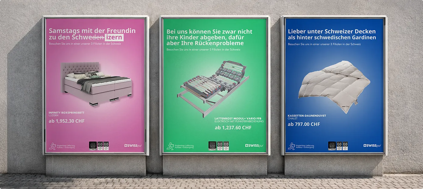 Drei Werbeplakate an einer Wand in verschiedenen Farben mit Betten- und Bettwarenangeboten von Swisspur, inklusive Boxspringbett, elektrischer Lattenrost und Daunendecke, mit Preisen in Schweizer Franken.