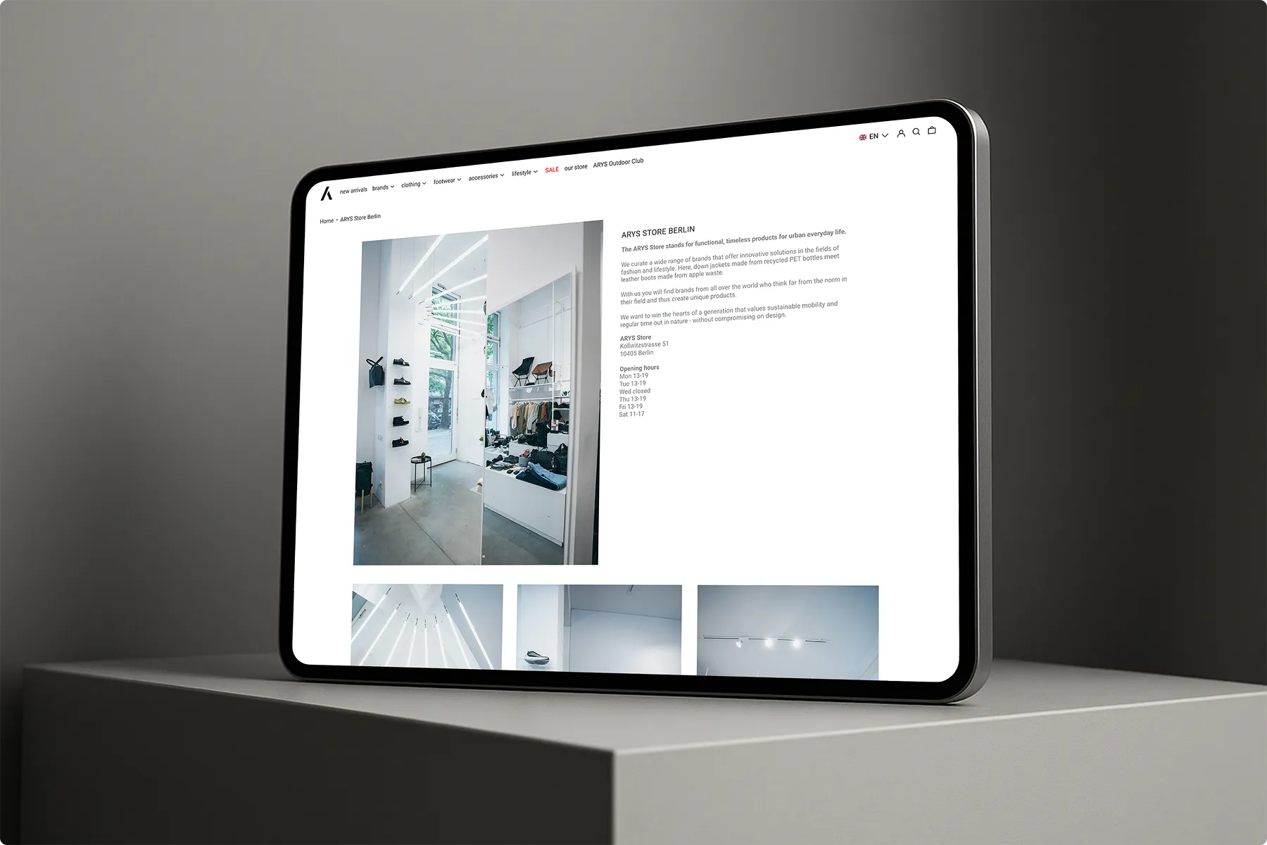 Tablet zeigt eine Webseite mit Informationen und Bildern vom ARYS Store Berlin, einem modernen Geschäft für nachhaltige Mode und Accessoires.