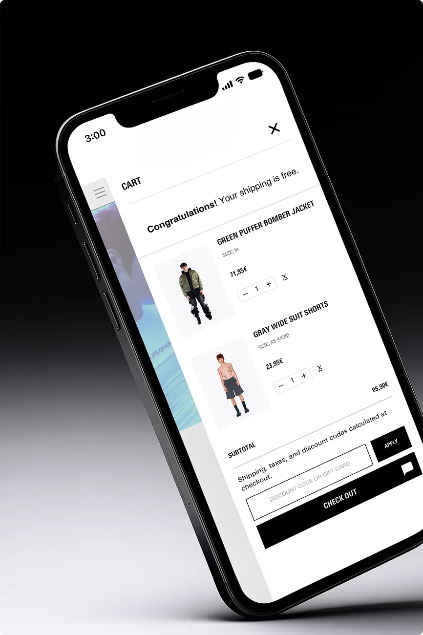 Smartphone zeigt Einkaufswagen mit grünem Puffer-Bomberjacke und grauen weiten Anzugshorts, Gesamtpreis 95,90 Euro.