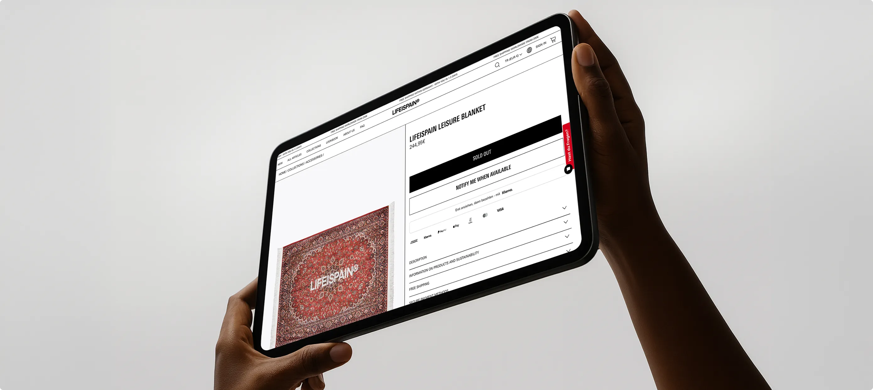 Person hält ein Tablet, auf dem eine ausverkaufte LIFEISPAIN Freizeitdecke angezeigt wird.