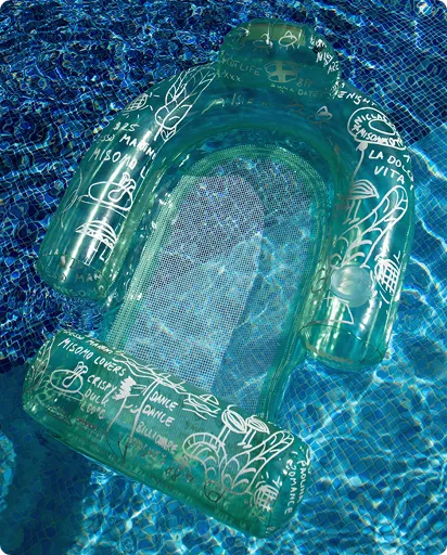 Transparenter aufblasbarer Pool-Sessel mit weißen Schriftzügen und Zeichnungen schwimmt im blauen Wasser eines Pools.