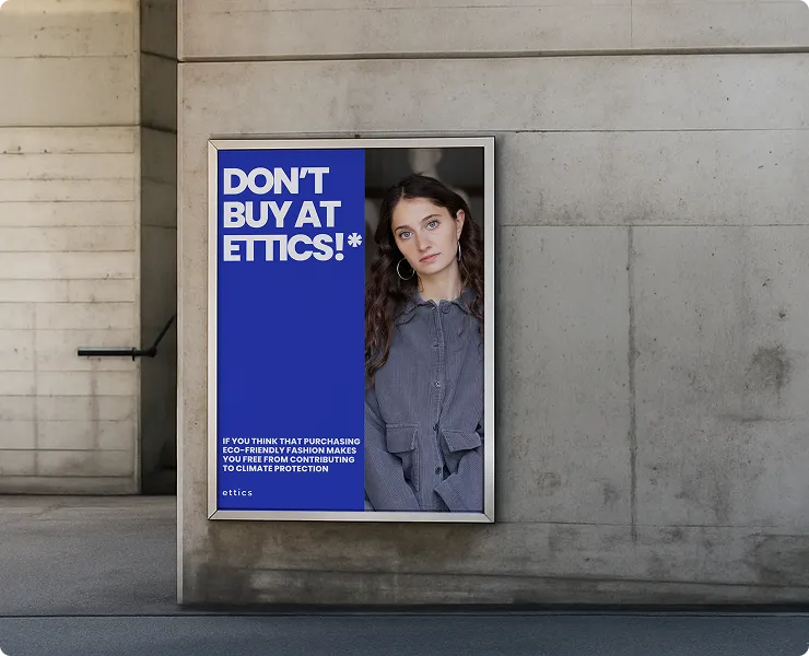Werbeplakat mit Text "DON'T BUY AT ETTICS!*" neben einem Porträt einer Frau mit langen Haaren und grauem Hemd, angebracht an einer Betonwand.