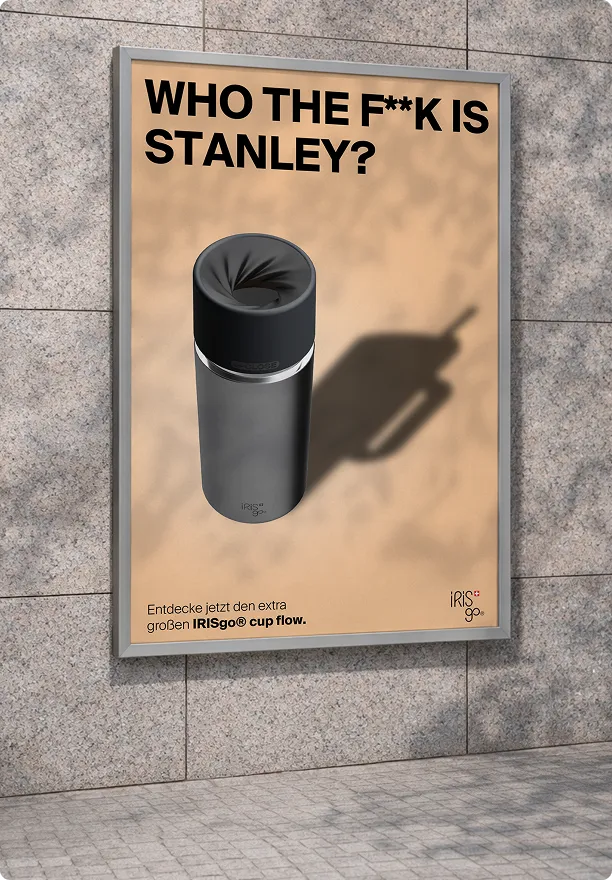Werbetafel an einer Mauer mit der Aufschrift: Wer zum Teufel ist Stanley? Darunter Abbildung eines schwarzen Trinkbechers und Text: Entdecke jetzt den extra großen IRISgo cup flow.
