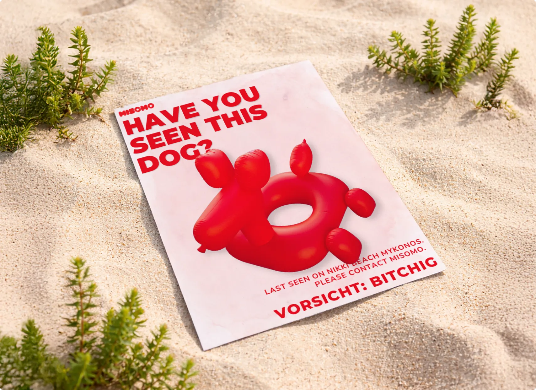 Suchplakat im Sand mit rotem aufblasbarem Hunde-Form-Schwimmring und der Aufschrift 'Have you seen this dog?'