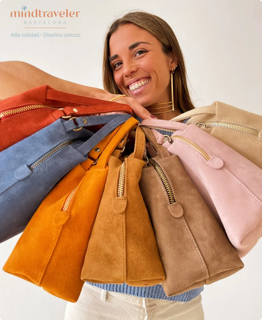 Frau mit einem Lächeln hält mehrere bunte Wildledertaschen mit Reißverschlüssen in der Hand.