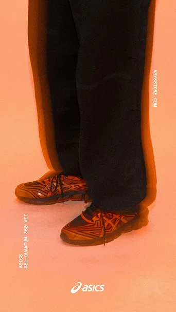 Person trägt schwarze Hose und orange-schwarze ASICS GEL-Quantum 360 VII Schuhe vor orangefarbigem Hintergrund.