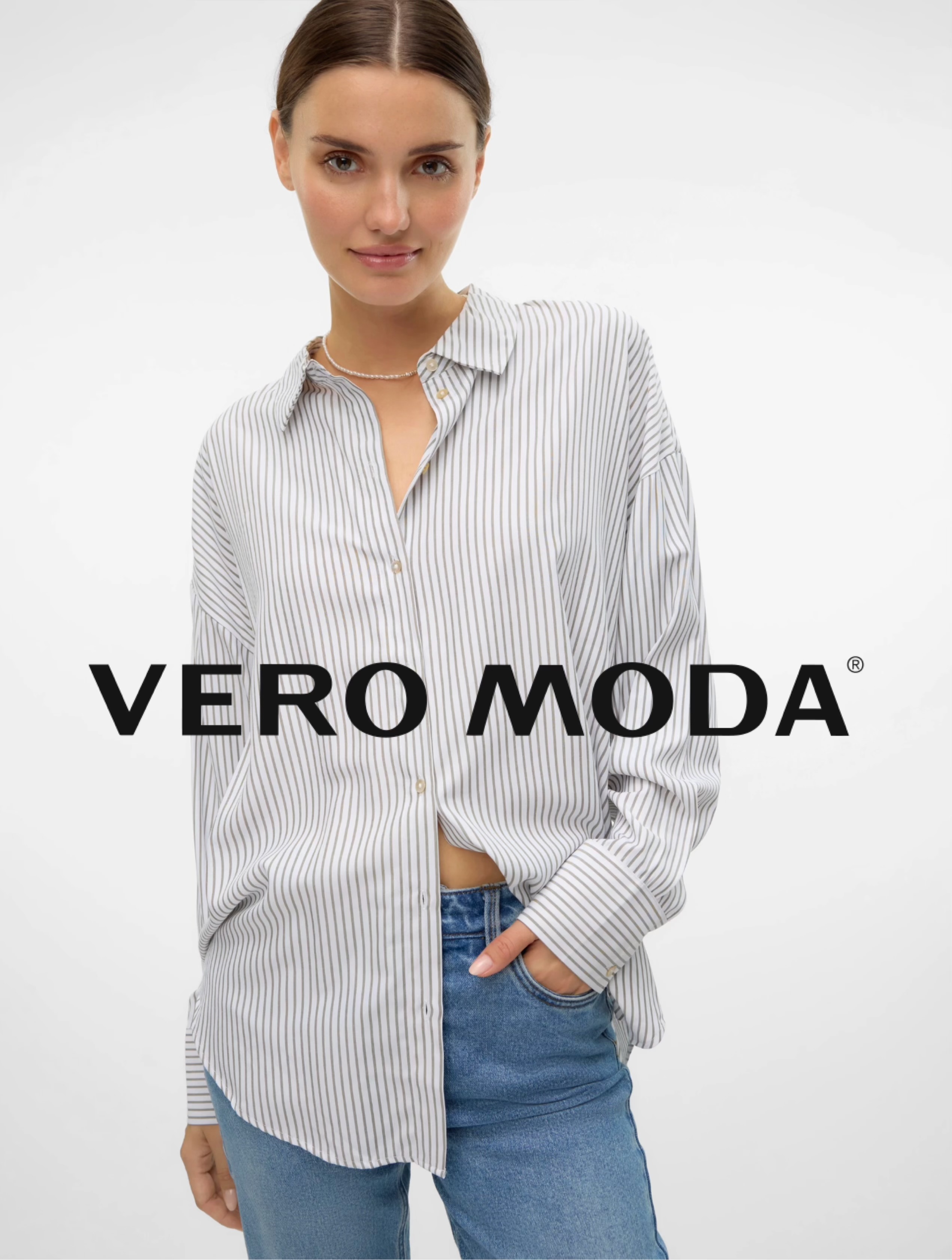 Frau trägt weiße, gestreifte Bluse und blaue Jeans vor weißem Hintergrund mit VERO MODA Schriftzug.