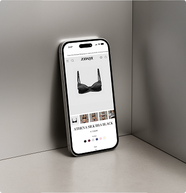 Smartphone zeigt eine Online-Shop-Seite mit einem schwarzen Seiden-BH namens Athena Silk Bra.