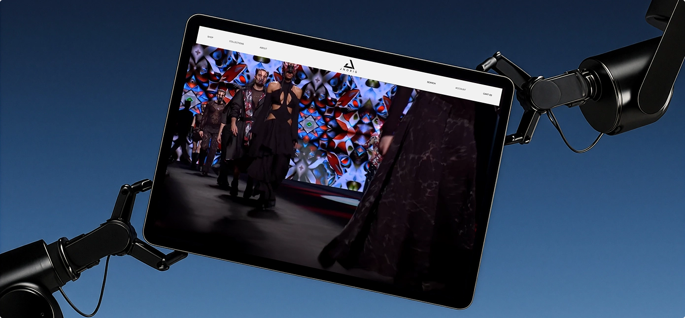 Tablet, der von zwei Roboterarmen gehalten wird, zeigt eine Modenschau mit Models auf einem Laufsteg vor einem bunten, kaleidoskopischen Hintergrund.