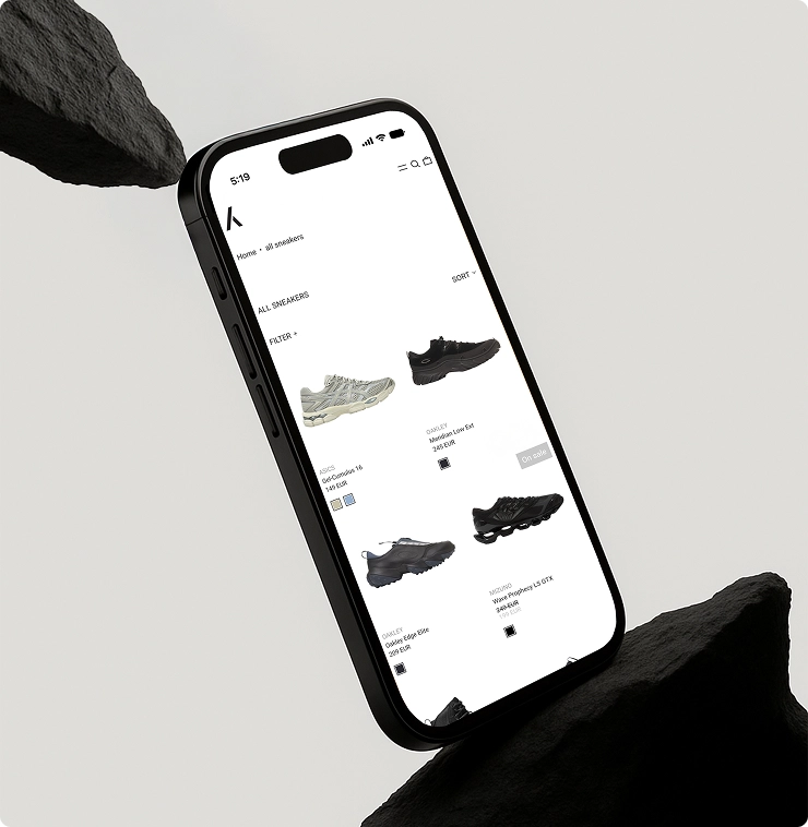 Smartphone zeigt eine Webseite mit verschiedenen Sneaker-Modellen und Preisen in einem Online-Shop.
