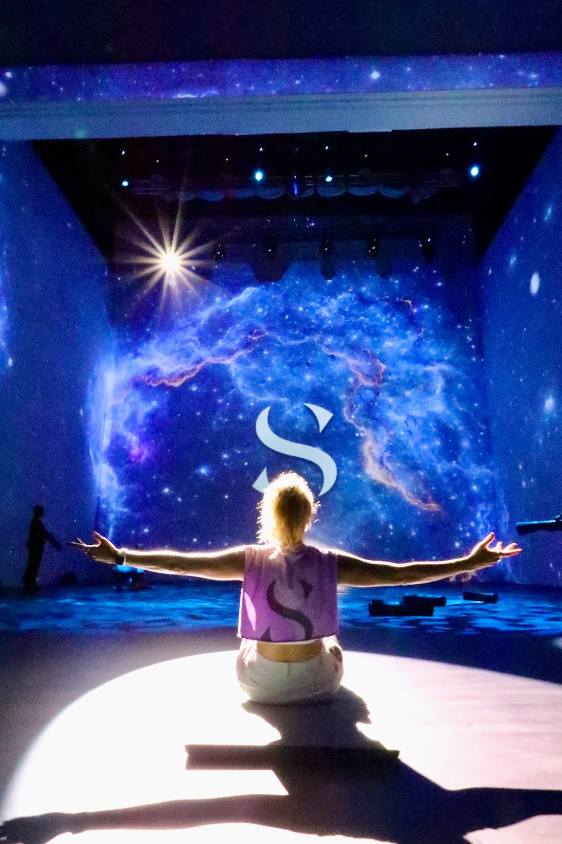 A guide with open arms under the projections at TODA