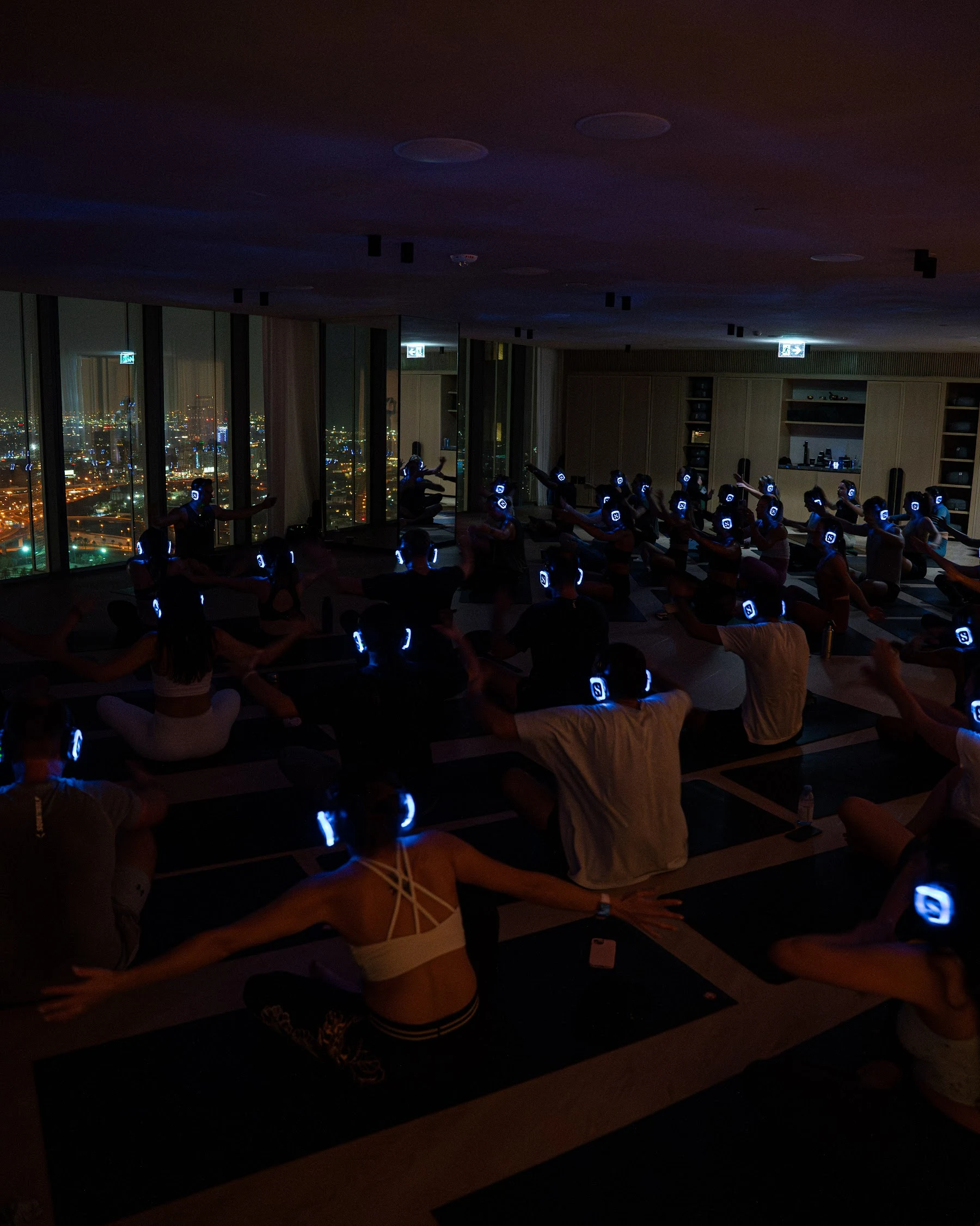 A full room in glowing headphones at SIRO One Za’abeel, Dubai lit up beyond the windows