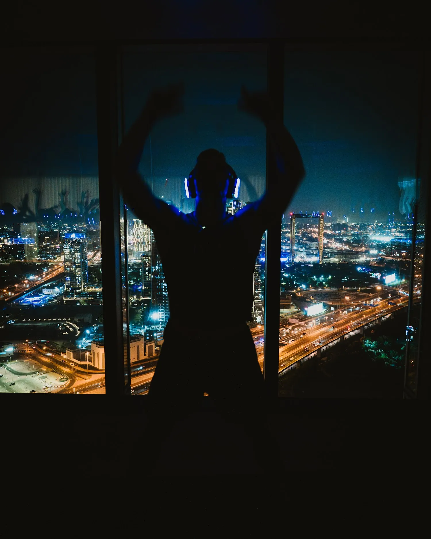 Arms raised in glowing headphones against the Dubai skyline at SIRO One Za’abeel