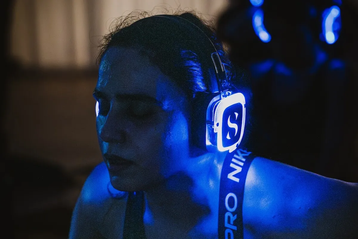Eyes closed in glowing Sanctum headphones at SIRO